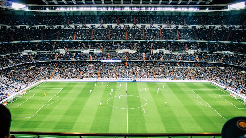 足球比赛看台上坐满了热情的球迷，挥舞着旗帜